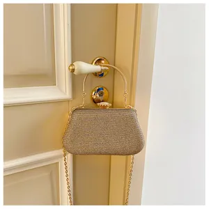 Detail of champagne gold sequin evening bag with metallic handle and jeweled clasp