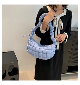 Detail of light blue quilted shoulder bag with fluffy cloud-style pleated handle texture
