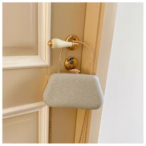Detailed close-up of champagne gold dinner clutch with rhinestone clasp and metal handle