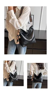 Detail of black PU leather tote with bohemian wide strap and plush bunny charm