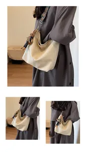 Detail of cream hobo tote bag featuring a geometric wide strap and a cute rabbit charm