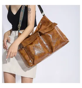 Detail of retro brown tote bag with multiple pockets and colorful embroidered strap