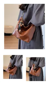 Detail of vintage brown tote bag with wide printed strap and cute rabbit charm