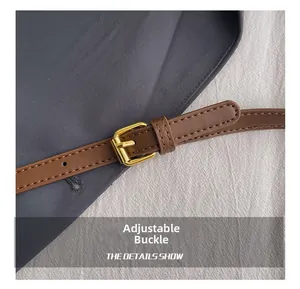 Detailed macro view of brown leather strap with adjustable golden metal buckle and stitching