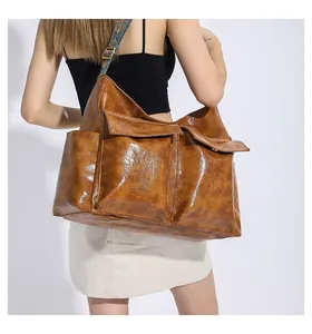Detail of vintage brown leather tote bag featuring utility pockets and ethnic strap