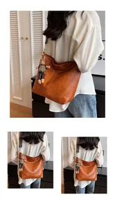 Detail of vintage brown tote bag with woven shoulder strap and cute rabbit pendant charm
