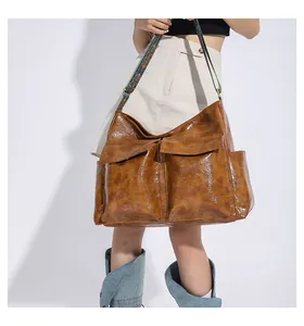 Detailed view of caramel tote bag with vintage texture and ethnic print strap