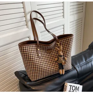 Detail of houndstooth tote bag featuring metallic Happy Girl plate and cute rabbit charm