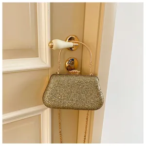 Detailed close-up of a sparkling gold evening bag hanging on a vintage door handle