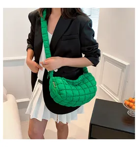 Detailed texture of green quilted puffer shoulder bag with soft padded handle and gold zipper
