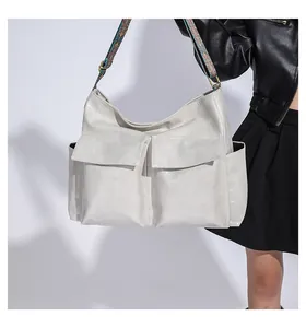 Close-up of cream tote bag featuring front flap pockets and retro ethnic pattern strap