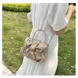 Détail du sac nuage plissé beige avec poignée ronde en strass et chaîne argentée