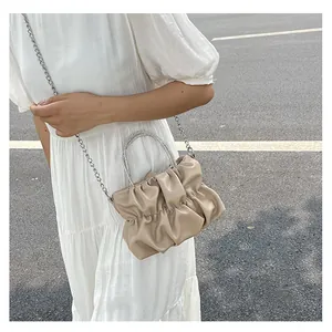 Détail du sac nuage plissé beige avec poignée en strass et bandoulière chaîne