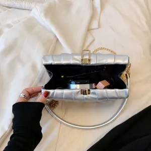 Detailansicht der silbernen Plissee-Tasche mit Platz für Make-up und goldener Kette