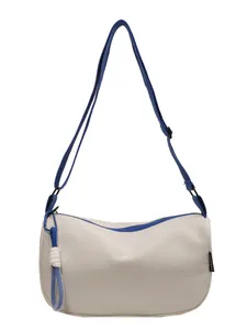 Minimalist beige crescent bag with blue trim and a stylish knot tassel detail