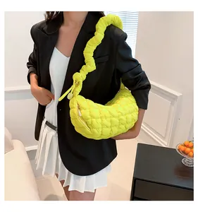 Detailed view of neon yellow quilted cloud bag with pleated wide shoulder strap