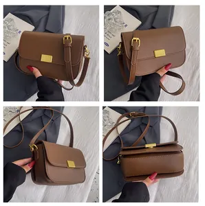 Detail view of a vintage dark brown leather crossbody bag with golden hardware accents