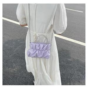 Détail du sac nuage plissé lilas avec poignée en strass étincelants et chaîne argentée