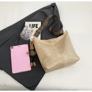 Detail of beige tote bag featuring ethnic print wide strap and cute bunny pendant