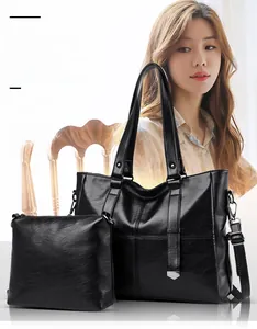Detail of black pebbled leather tote bag with inner pouch and silver hardware accents