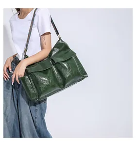 Detail of dark green vintage tote bag featuring multiple pockets and a colorful woven strap