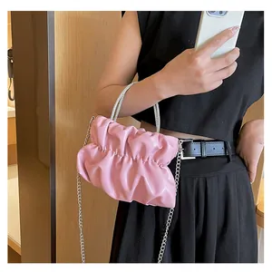 Détail du sac nuage plissé rose avec poignées en strass et bandoulière en chaîne argent