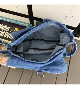 Interior view of large blue denim crossbody bag showing spacious storage and pockets