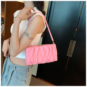 Detail einer rosa gerafften Schultertasche mit Ledertextur und goldenem Magnetverschluss