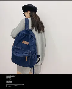 Details des dunkelblauen Denim-Rucksacks mit Leder-Reißverschluss und Marken-Leder-Patch