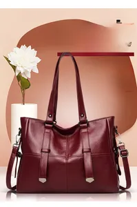 Detailed macro view of the wine red leather tote bag with elegant metallic hardware