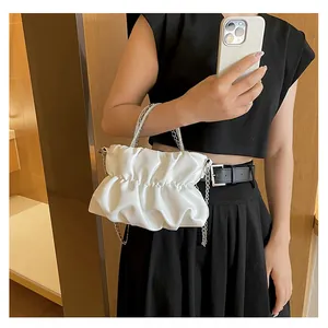Détail du sac nuage plissé blanc avec poignée en strass et bandoulière en chaîne