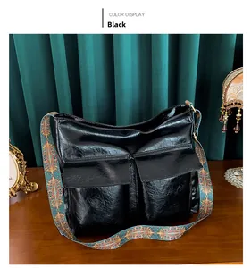 Detail of black glossy faux leather tote bag with vibrant ethnic style woven shoulder strap