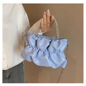 Détail du sac nuage plissé bleu clair avec poignée en strass et chaîne en argent