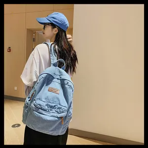 Seitenansicht eines hellblauen Denim-Rucksacks mit Lederetikett an einem Model