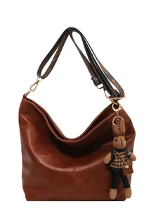 Retro brown oversized hobo tote bag with vintage patterned strap and bunny pendant detail