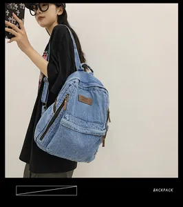 Detail view of large denim backpack side pocket and adjustable black shoulder strap