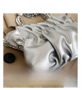 Detail of silver pleated cloud bag with rhinestone handle and metallic chain strap