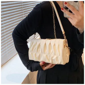 Detail der cremefarbenen Wolken-Tasche mit vertikalen Falten und goldener Kette