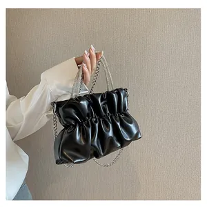 Détail d'un sac nuage noir froncé avec une poignée étincelante en strass et chaîne argent