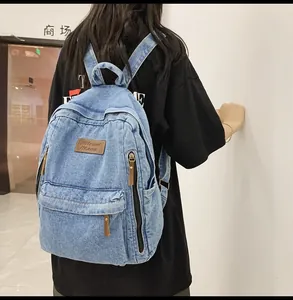 Detail view of light blue denim backpack with leather 7Street logo and large side pocket