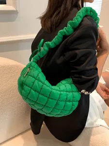 Quilted green puffy shoulder bag with ruched strap and minimalist crescent design
