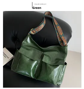 Detail of green oil-wax texture tote bag with a decorative ethnic pattern wide strap