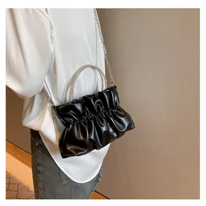 Détail d'un sac nuage plissé noir avec poignée en strass et bandoulière chaîne argentée