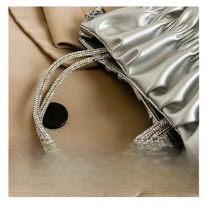 Detailed macro view of the silver pleated cloud bag with sparkling rhinestone handle straps