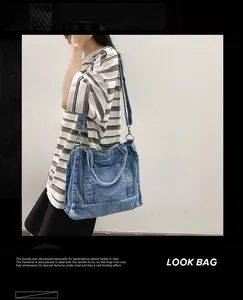 Detail of blue denim tote bag with front pocket and adjustable shoulder strap for daily use