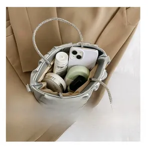 Detail view of silver pleated cloud bag showing interior capacity and rhinestone handle
