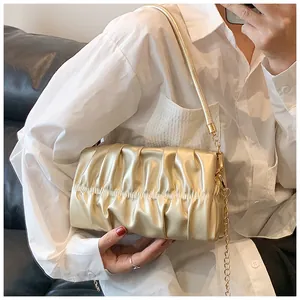 Detailansicht der champagnergoldenen Falten-Tasche mit Metallkette und Schultergurt