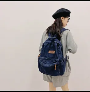 Details des Vintage-Jeans-Rucksacks mit Leder-Logo-Patch und Front-Reißverschlusstasche
