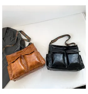 Detail view of large retro tote bags in brown and black with jacquard shoulder straps