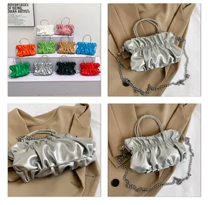 Macro shot of silver pleated cloud bag with rhinestone round handle and metal chain detail